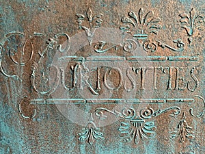 Curiosities sign in bronze and verdigris photo